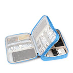 Organizador azul cielo abierto con cables, tarjetas y power bank